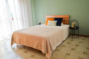 a bedroom with a large bed with an orange blanket at "La Villa dei Nonni" appartamento in Bergamo
