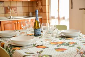 una mesa con copas y una botella de vino en "La Villa dei Nonni" appartamento, en Bérgamo