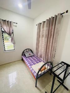 Cama pequeña en habitación con ventana en Homestay CikguMa - Netflix & Wifi en Kota Bharu