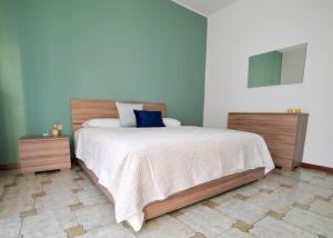 a bedroom with a large bed with a blue pillow at "La Villa dei Nonni" appartamento in Bergamo +8 photos