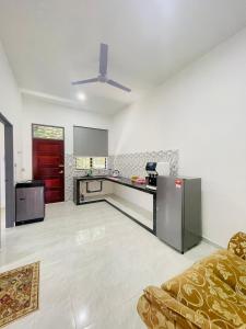 a large kitchen with a couch in a room at Homestay CikguMa - Netflix & Wifi in Kota Bharu