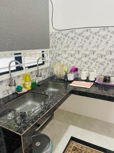 a kitchen with two sinks and a counter top at Homestay CikguMa - Netflix & Wifi in Kota Bharu