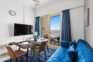 - un salon avec un canapé bleu et une table dans l'établissement StoneTree - Stylish 1BR near Marina Walk, à Dubaï