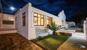 ein weißes Haus mit einer Bank im Hof in der Unterkunft Batavia Boutique Hotel in Stellenbosch