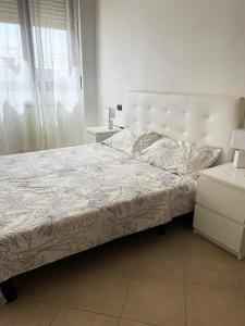 a bedroom with a large bed with a white headboard at The Queen's Apartments in Sassari
