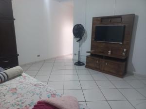 a bedroom with a television and a floor fan at Suits - Canto do sabia in Brotas