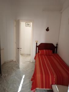 1 dormitorio con 1 cama con manta de rayas rojas en Mia casa en La Goulette