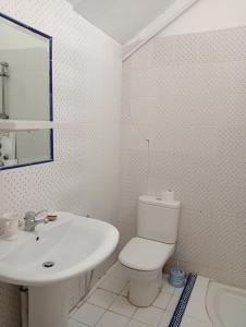 a white bathroom with a toilet and a sink at Mia casa in La Goulette