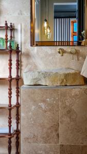 ein Bad mit einem Waschbecken und einem Spiegel in der Unterkunft Batavia Boutique Hotel in Stellenbosch