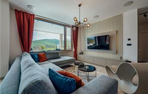 uma sala de estar com um sofá e uma grande janela em Nice Home In Cista Velika With Sauna em Velika Cista