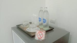 a table with bottles and glasses and a no drinking sign at Luancharoen Home Resort Phuket in Thalang