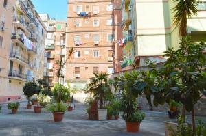 um pátio com vasos de plantas em frente aos edifícios em “La Casa di Margi” em Nápoles
