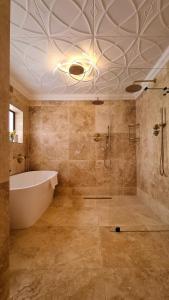 Das Bad ist mit einer Badewanne und einer Badewanne ausgestattet. in der Unterkunft Batavia Boutique Hotel in Stellenbosch