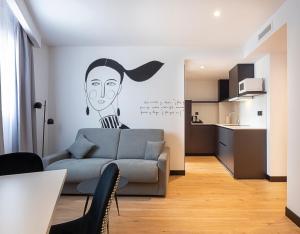 a living room with a couch and a drawing on the wall at Sercotel Plana Suites in Vall de Uixó