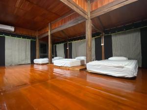 3 łóżka w pokoju z drewnianą podłogą w obiekcie Ba Bể Hada Homestay w mieście Ba Be18