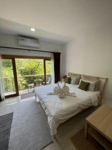 a bedroom with a bed with a flower on it at Luancharoen Home Resort Phuket in Thalang