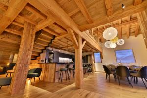 a dining room and kitchen with wooden ceilings and a table and chairs at Epicime Lodge in Landry