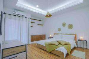 a white bedroom with a large bed and a window at Perfect villa for your vacation in Dubai