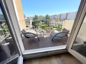 balcone con 2 sedie e un tavolo sopra di Grand appartement idéalement situé a Villeurbanne