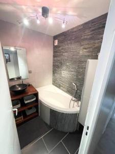 bagno con vasca e lavandino di Grand appartement idéalement situé a Villeurbanne