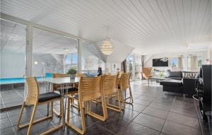 een eetkamer en een woonkamer met een tafel en stoelen bij Lovely Home In Fan With Private Swimming Pool, Can Be Inside Or Outside in Fanø