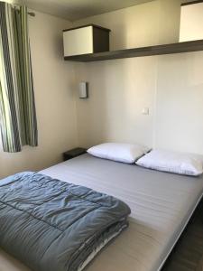 a large bed in a room with at Mobil home 6 personnes dans camping 5* in Houlgate +16 photos