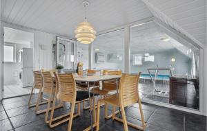 een eetkamer met een tafel en stoelen bij Lovely Home In Fan With Private Swimming Pool, Can Be Inside Or Outside in Fanø