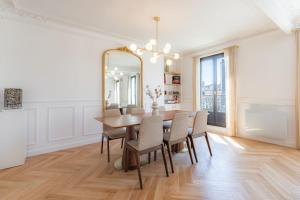 a dining room with a table and chairs and a mirror at Charming apartment in the heart of Paris with rooftop views in Paris