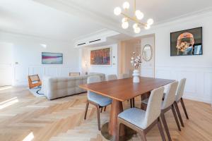 a dining room with a table and chairs and a couch at Charming apartment in the heart of Paris with rooftop views in Paris