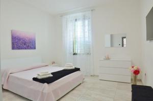 um quarto branco com uma cama grande e uma cómoda em “La Casa di Margi” em Nápoles