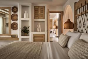 a bedroom with a large bed and a mirror at Lesante Cape Resort & Villas - The Leading Hotels of the World in Akrotiri