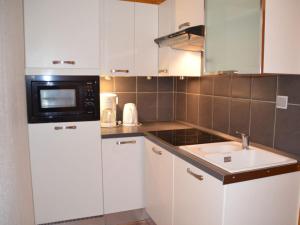 里蒙紐耶的住宿－Appartement Les Menuires, 2 pièces, 6 personnes - FR-1-452-111，厨房配有白色橱柜、微波炉和水槽。
