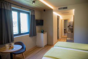 a bedroom with two beds and a table and a window at Balibà Ride & Relax in Castione Andevenno