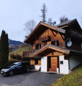 a black car parked in front of a house at 8-Person Chalet with Hot Tub in Portes du Soleil in Montriond