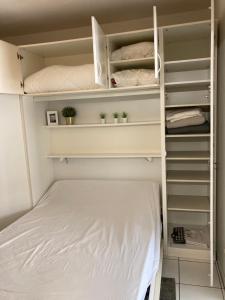 a bedroom with a bed and white shelves at Strandstudio in hartje Koksijde in Koksijde +37 photos
