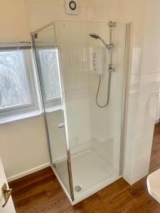 a shower with a glass door in a bathroom at 5 Bedroom house in DA7 in Erith