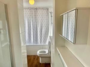 a white bathroom with a toilet and a shower at 5 Bedroom house in DA7 in Erith