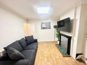 un soggiorno con divano e camino di 5 Bedroom house in DA7 a Erith