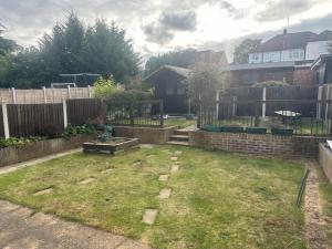 a backyard with a fence and a yard withgrass at 5 Bedroom house in DA7 in Erith
