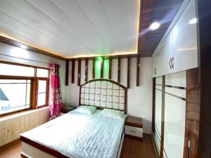 Schlafzimmer mit einem Bett und einem Fenster in der Unterkunft Sheen Homestay in Gulmarg