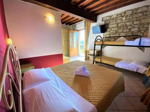 - une chambre avec 2 lits superposés avec un cœur rose sur un lit dans l'établissement Tenuta La Lupa, à Castellina Marittima