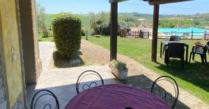 a patio with a purple table and chairs on a patio at Tenuta La Lupa in Castellina Marittima