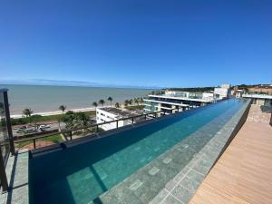 a swimming pool with a view of the beach at Flat FM20 Cabo Branco Ocean - By Almare in Tambaú