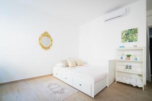 a white bedroom with a bed and a mirror at APT per coppie nel cuore di Desenzano CASTELLO in Desenzano del Garda