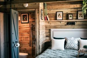 a bedroom with a wooden wall with a bed at The Potting Barn Near Porthcothan in Saint Ervan +32 photos
