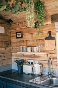 a kitchen with wooden walls and a counter with a sink at The Potting Barn in Saint Ervan