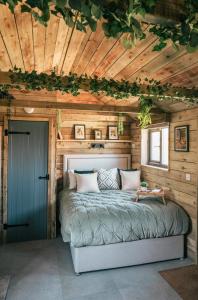a bed in a room with a wooden ceiling at The Potting Barn in Saint Ervan
