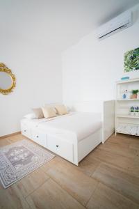 um quarto branco com uma cama e piso em madeira em APT per coppie nel cuore di Desenzano CASTELLO em Desenzano del Garda