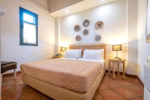 a bedroom with a bed and two plates on the wall at The Varos Residences Hotel in Város
