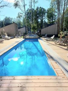 a swimming pool with blue water on a wooden deck at Stunning Seaside Haus in Palanga +16 photos